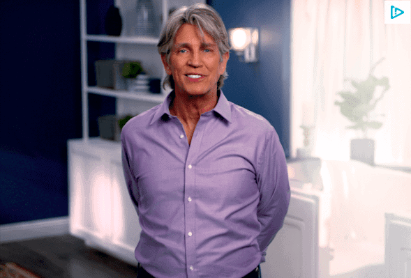 Older grey haired man, in a purple button up long sleve shirt