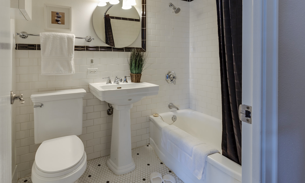 White ceramic toilet bowl beside pedestal sink and bathtub